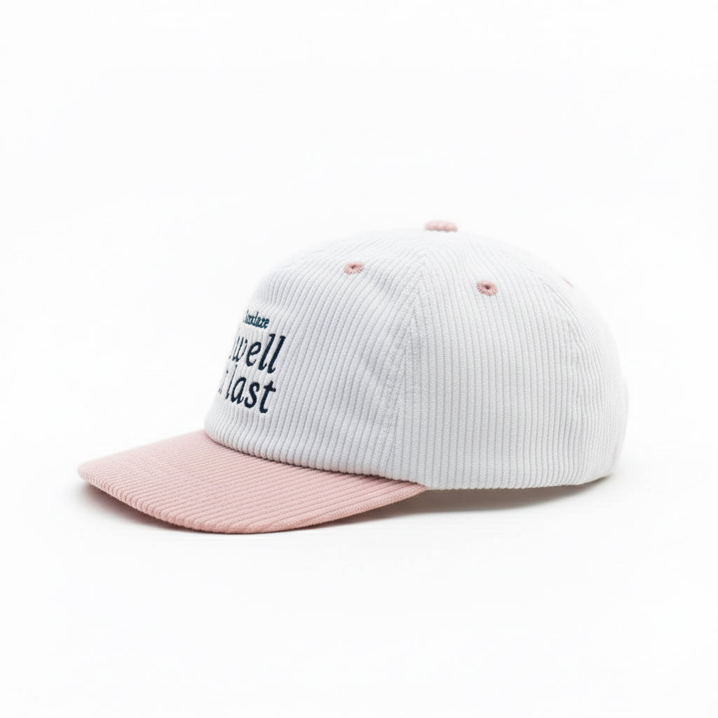 White and pink cap with 'Swell at last' text on a white background