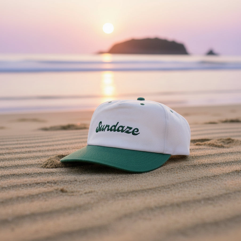 White and green cap with 'Sundaze' logo on a wooden stump in a forest setting